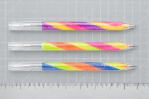 Three transparent rainbow gel pens arranged for barrel and point configuration review