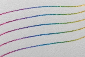 Fine glitter ink lines changing from pink through blue to green and yellow